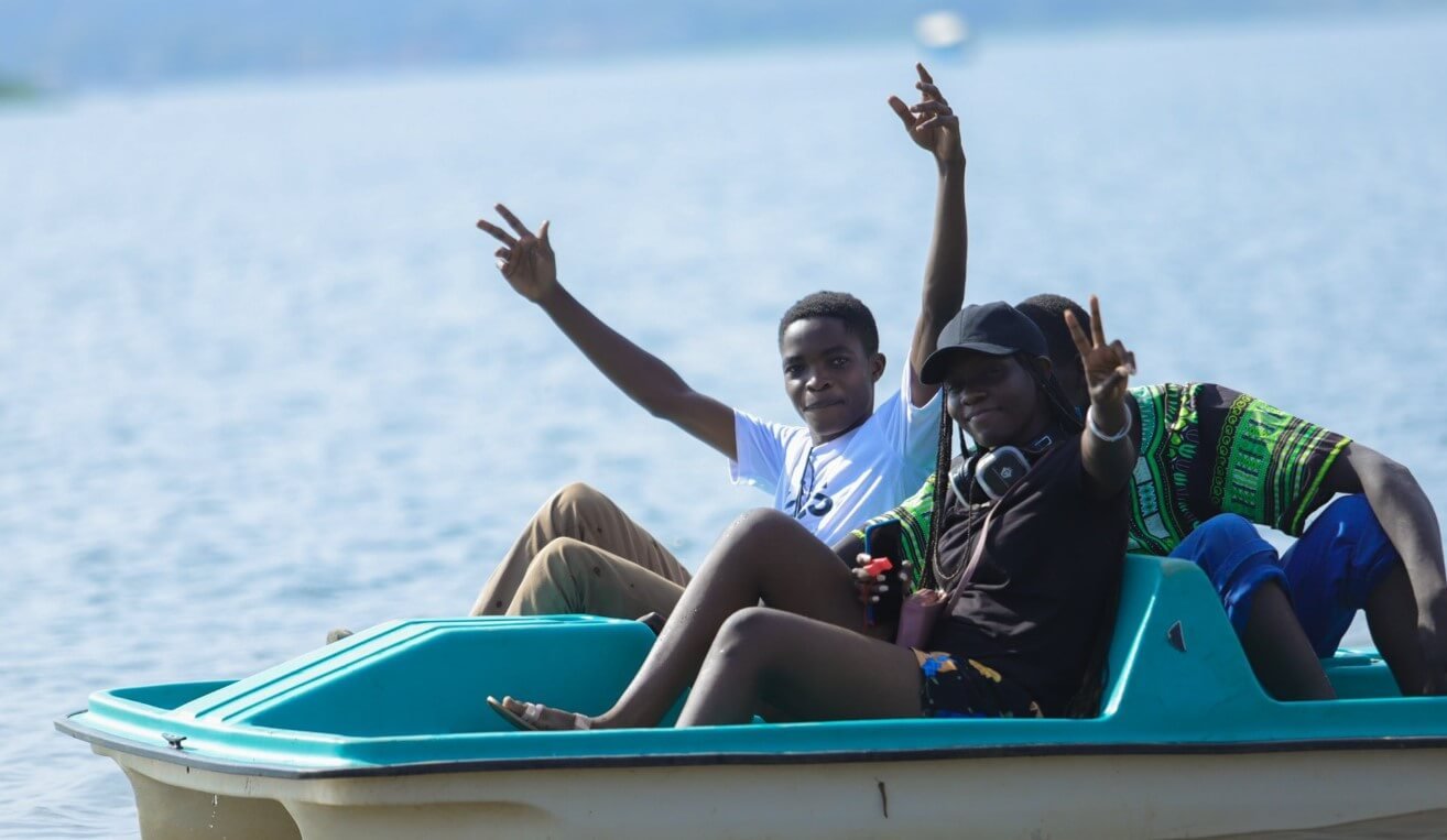 People paddling a colorful paddle boat on the water.